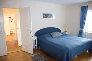 韦斯特维克Värmvik Gårdskontor的一间卧室配有蓝色的床和蓝色的毯子