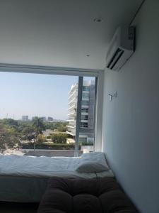 卡塔赫纳Playa la Boquilla, Apto dentro Condominio Hotel Sonesta的一间卧室设有一张床和一个大窗户