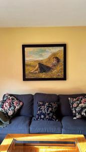 圣克鲁斯德拉塞罗斯apartamentos turisticos san juan de la peña的客厅配有蓝色沙发和绘画作品