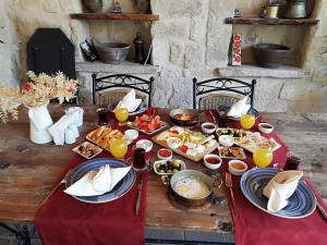 内夫谢希尔Cappadocia Old Houses的一张木桌,上面有食物和饮料