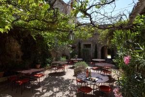 阿维尼翁新城阿特利亚酒店的花园内带桌椅的庭院