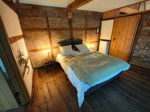 斯图蒙Le Clos des Brumes的铺有木地板的客房内设有一间卧室和一张床。