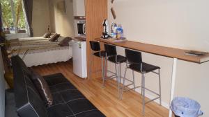 巴塞罗那格斯亚大道舒适之家酒店的一间厨房,内设一个带凳子的酒吧