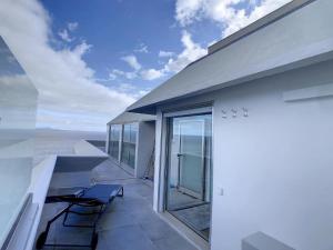 卡尼索Luxurious Penthouse Suite direct at sea的阳台配有椅子,享有海景。