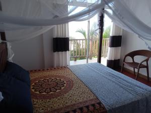 马特勒Himana Beach Rest的一间卧室配有一张带蓝色毯子的床和窗户。