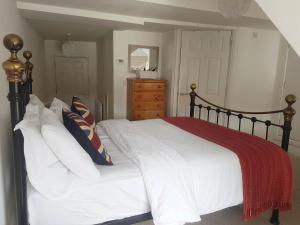 沃里克Warwick Market Place Apartment的一间卧室配有一张带白色床单和红色毯子的床。