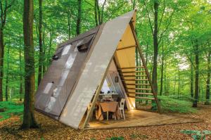 拉科纳Casa Dei Prati Camping Village的树林里带桌子的帐篷