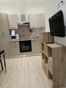 安科纳Appartamento Turistico "ortensia"的一间带木制橱柜和平面电视的厨房