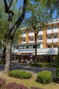 比比翁Hotel Renania的一座建筑前有树木的酒店