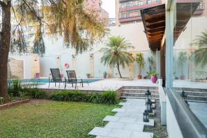 圣米格尔·德·图库玛Hotel Embajador的一个带游泳池和房子的后院