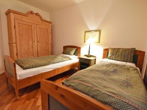 梅拉诺Apartment Villa Esperia by Interhome的一间卧室设有两张床和一张桌子上的台灯。