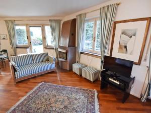 梅拉诺Apartment Villa Esperia by Interhome的带沙发和钢琴的客厅