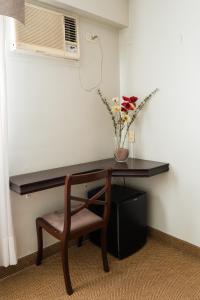 圣米格尔·德·图库玛Hotel Embajador的一张桌子、椅子和花瓶