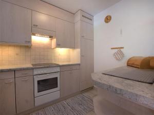 圣莫里茨圣莫里茨彻萨弗洛拉公寓的厨房配有白色橱柜和台面