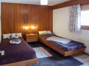 韦尔比耶Apartment Val Neige 11 by Interhome的木镶板客房内的两张床