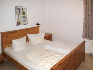 岑平Apartment Achterwasser - ZEM100 by Interhome的一间卧室配有一张带白色床单的木床