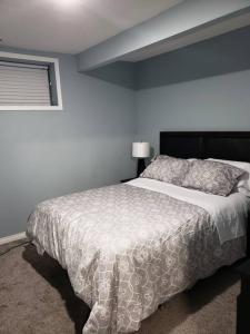 卡尔加里Cozy Two Bedroom Guest Suite in NW的卧室配有一张带白色棉被的床和窗户。