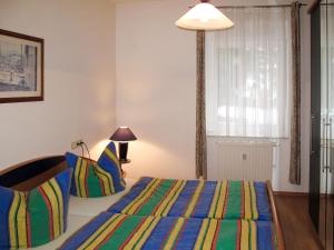 洛丁Apartment Haus Berlin-3 by Interhome的一间卧室配有一张带彩色条纹毯子的床