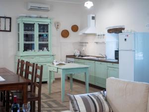 泽敏Holiday Home Marija - ROJ422 by Interhome的厨房配有绿色橱柜、桌子和冰箱。