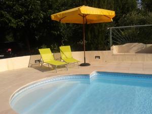 伊斯内斯Wisteria的游泳池旁的两把黄色椅子和一把遮阳伞