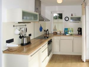 卡尔斯哈根Holiday Home Katja by Interhome的厨房配有白色橱柜和木制台面