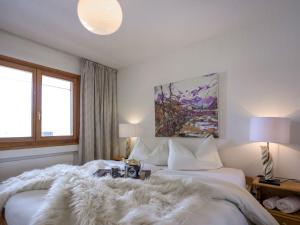 圣莫里茨切萨卢丹斯公寓的一间卧室配有两张床和毛绒毯子