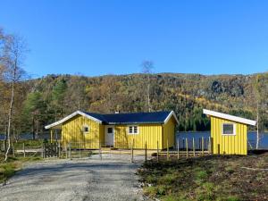 ÅseralHoliday Home Oddbu - SOW103 by Interhome的靠近水体的黄色建筑