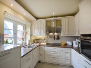 加格尔Holiday Home Bel Air by Interhome的厨房配有白色橱柜和水槽
