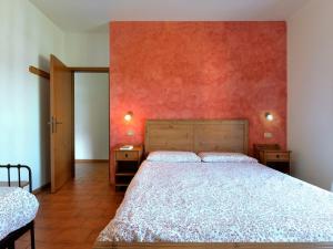 卡尔多纳佐Apartment Anna-2 by Interhome的一间卧室设有一张床和红色的墙壁