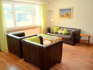 圣莫里茨欧瓦考茨纳12/14公寓的客厅配有两张真皮沙发和一张桌子