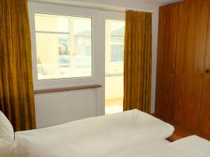 圣莫里茨欧瓦考茨纳12/14公寓的一间卧室设有一张床和一个窗口
