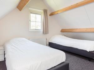 韦默尔丁厄Holiday Home Zeeuwse Cottage Wemeldinge-5 by Interhome的配有2张床的白色墙壁和窗户。