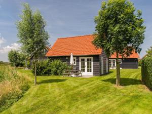 韦默尔丁厄Holiday Home Zeeuwse Cottage Wemeldinge-3 by Interhome的庭院里一座带橙色屋顶的小房子