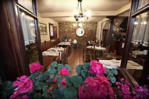 桑提亚纳德玛索拉纳旅馆的前景餐厅,设有桌子和粉红色的鲜花