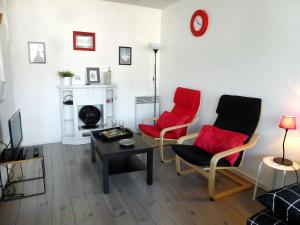 多维尔Apartment Les Marinas-7 by Interhome的客厅配有2把红色椅子和桌子