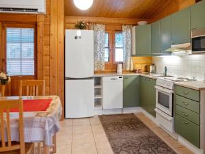 拉赫登佩拉Holiday Home Kurre by Interhome的厨房配有绿色橱柜和白色冰箱
