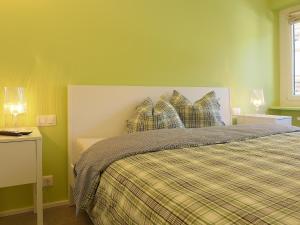 圣莫里茨Apartment Chesa La Soliva by Interhome的绿色卧室配有一张带拼盘床单和枕头的床