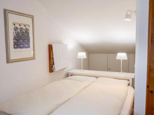 锡尔斯玛丽亚Apartment Chesa Polaschin E - E21 - Sils by Interhome的一间白色卧室,配有两张床和两盏灯。