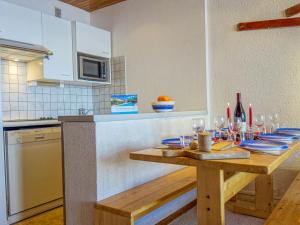 蒂涅Apartment Les Hauts du Val Claret - Val Claret-22 by Interhome的厨房配有带酒杯的木桌