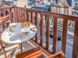 多维尔Apartment Le Hoc by Interhome的阳台上的餐桌上放着一盘食物