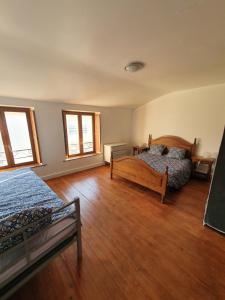 米尔库尔Gite des luthiers的一间卧室设有两张床,铺有木地板