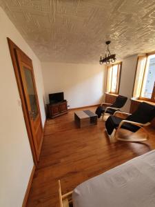 米尔库尔Gite des luthiers的客厅配有床和椅子以及电视