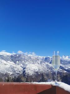 谷雪维尔La Tania 309 Le Britania的坐在雪覆盖的山顶上,喝一杯葡萄酒