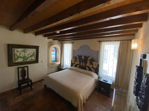 圣米格尔-德阿连德Casa Árbol Hotel的一间设有床铺的卧室,位于带窗户的房间内