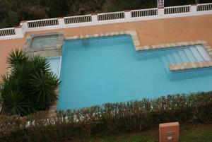 阿莱奥尔EL MIRADOR的一座大型蓝色游泳池,位于大楼旁边