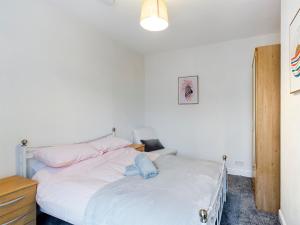 切斯特Cheerful 3 bedroom home with free parking and WIFI的一间卧室配有两张带白色床单和粉红色枕头的床。