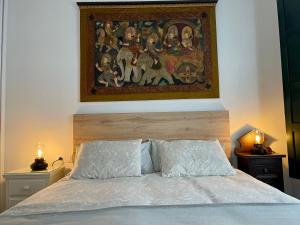奥伦塞Afiador的卧室配有床上方的绘画作品