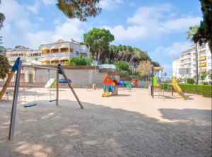 罗列特海岸SeaHomes Vacations, LA MER BLEUE, beach&pool, PK, full equipped in Fenals Beach的公园内带滑梯和游戏设备的游乐场