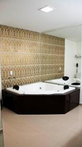 波多韦柳金座大酒店 的设有带大浴缸及镜子的浴室