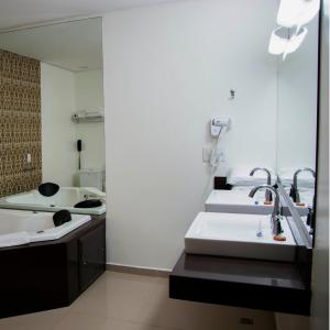 波多韦柳金座大酒店 的一间带三个水槽和镜子的浴室